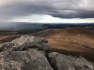 At the top of Clachnaben with rain in the distance